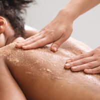 African american lady having skin scrubbing procedure at spa salon
